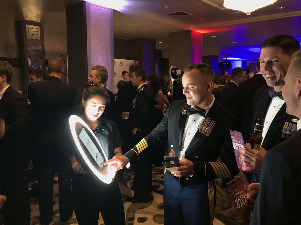 Attendant holding a portable booth at a reception