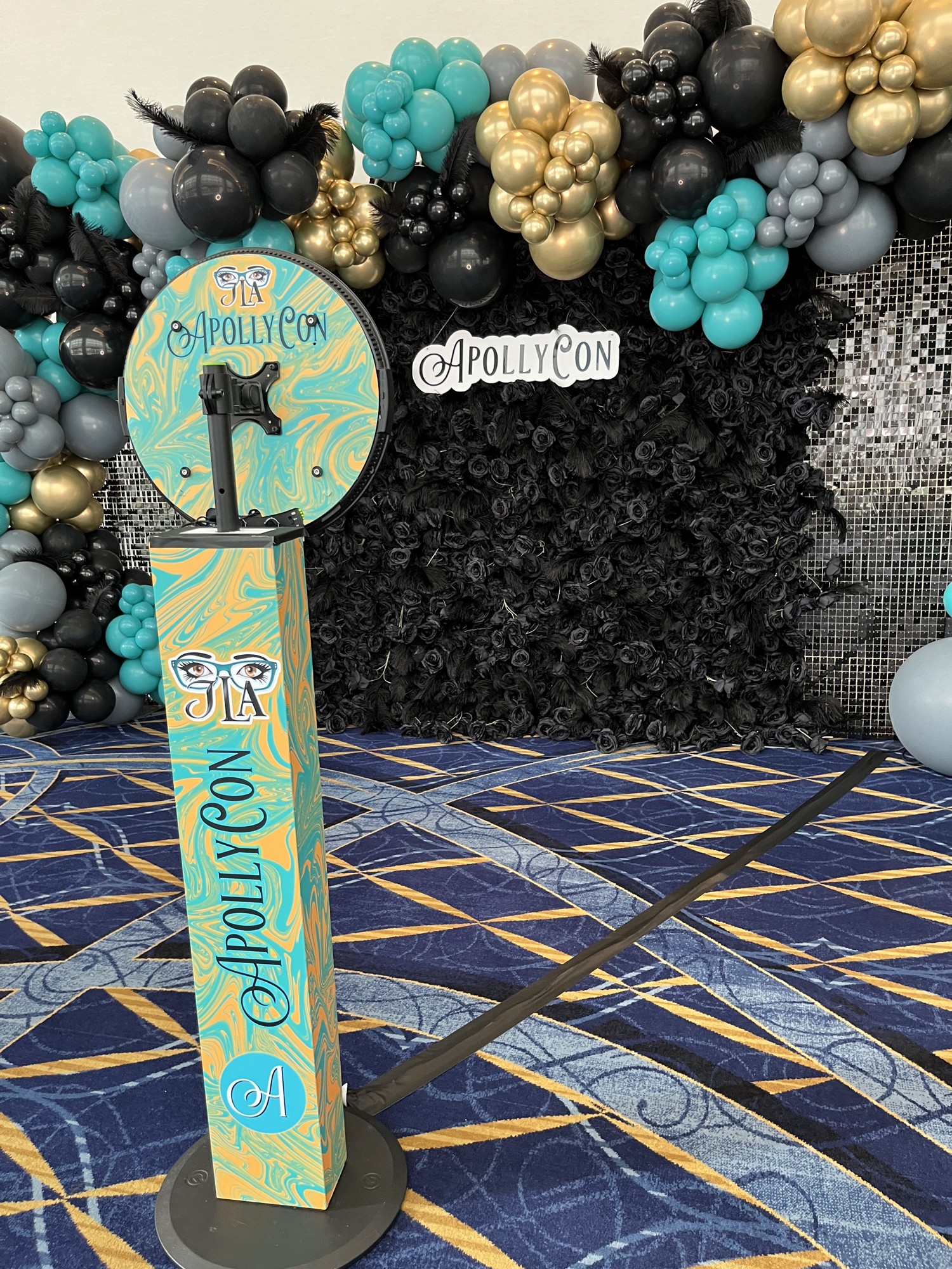 ApollyCon photo booth wrapped in the event’s turquoise and gold artwork