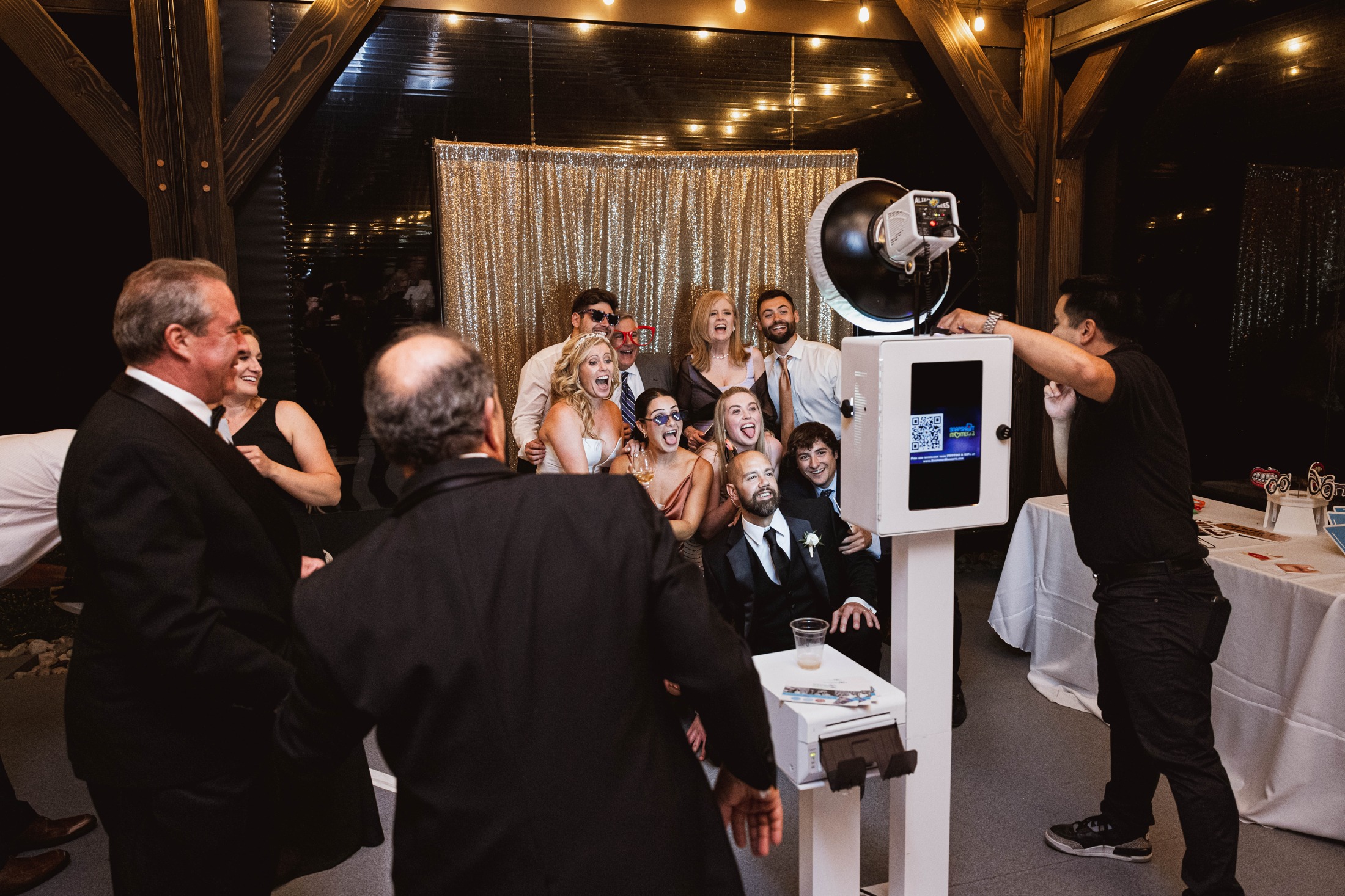 Wedding guests choosing props and taking photos together at their reception