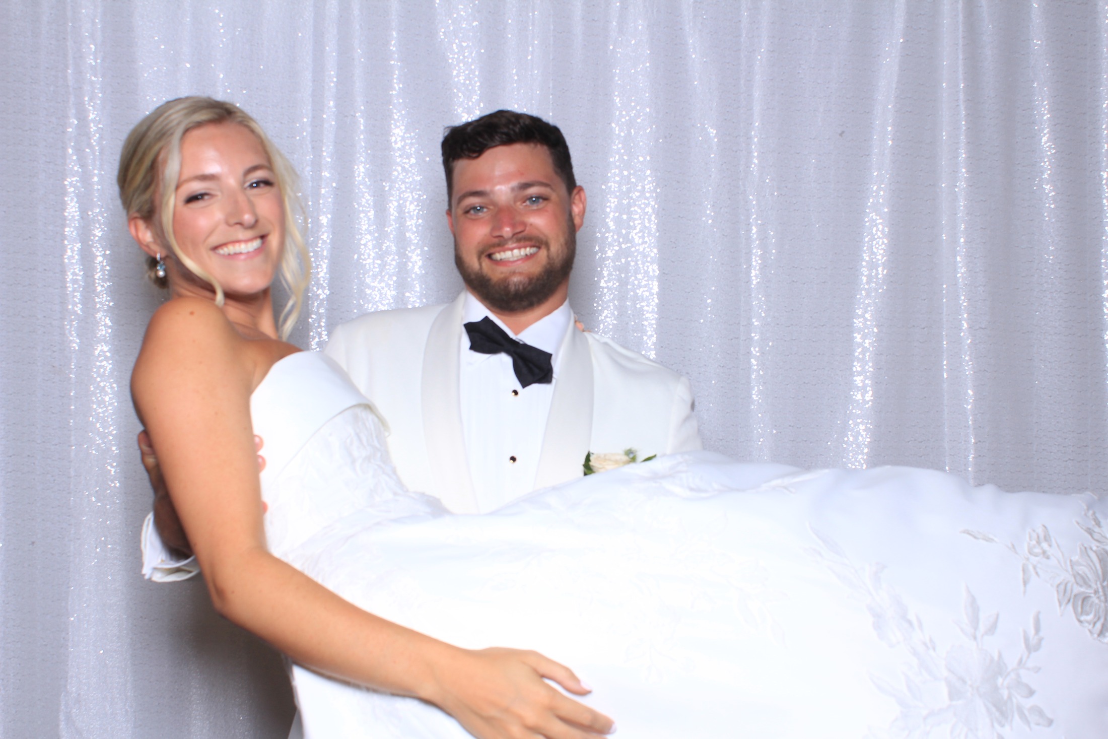 Bride and groom laughing together at their wedding photo booth