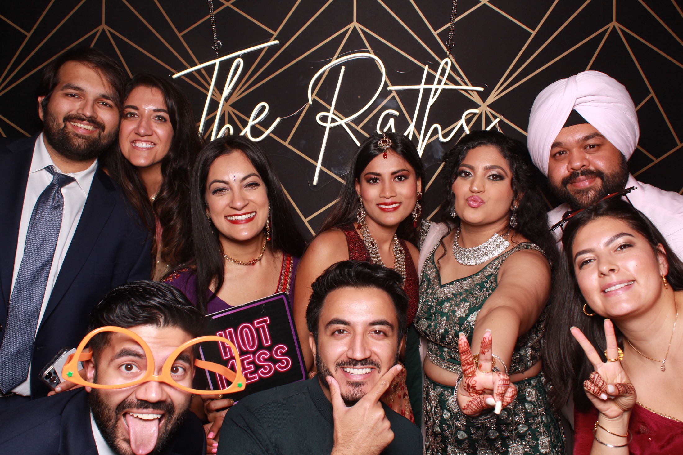 Friends posing together with personalized wedding backdrop