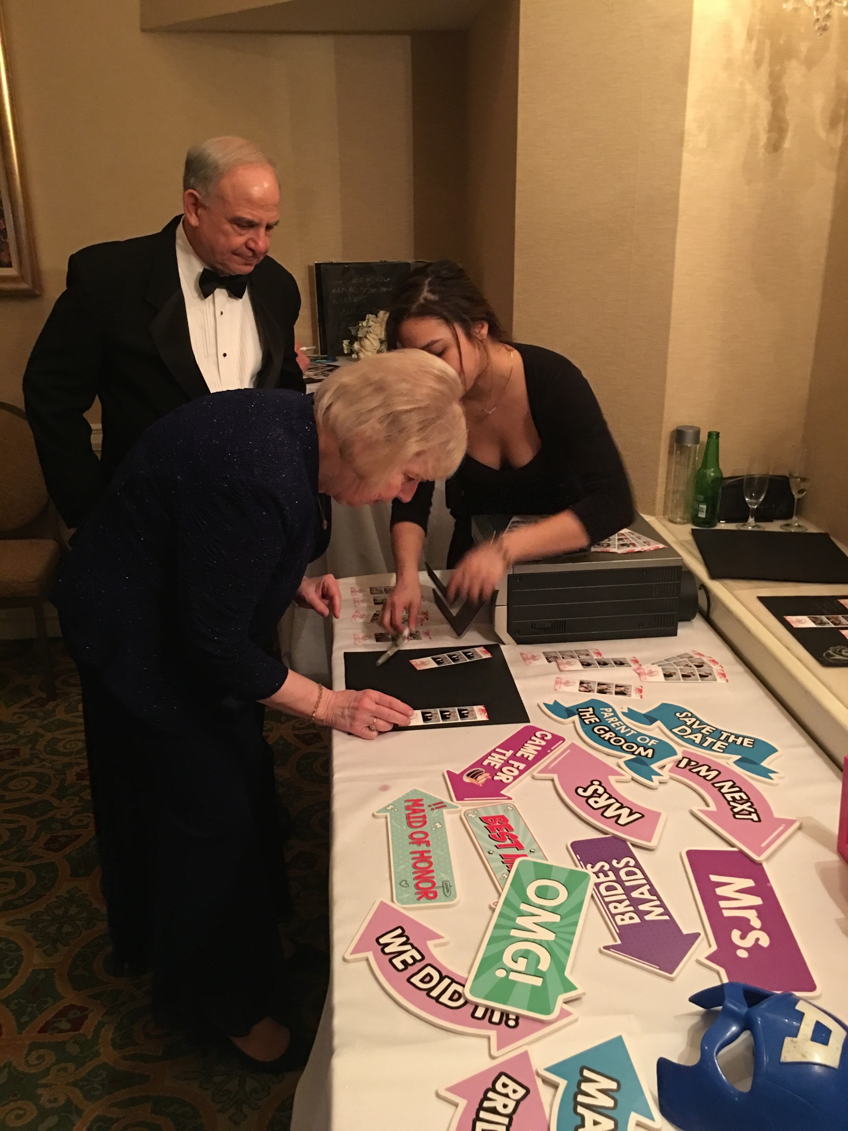 A wedding guest choosing from the photo booth prop table
