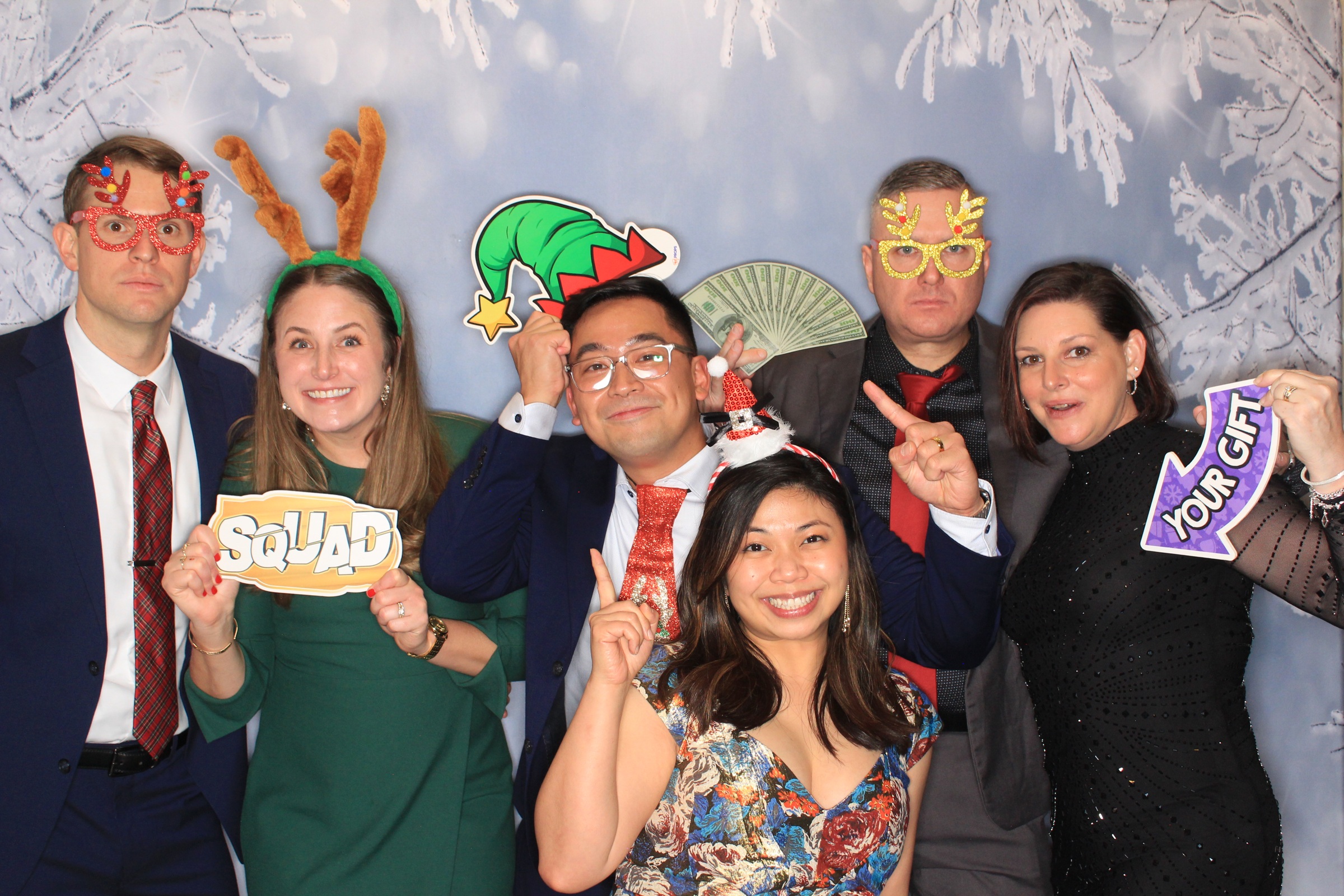 Real PAG Glacier Gala guests posing with festive props in front of a winter backdrop