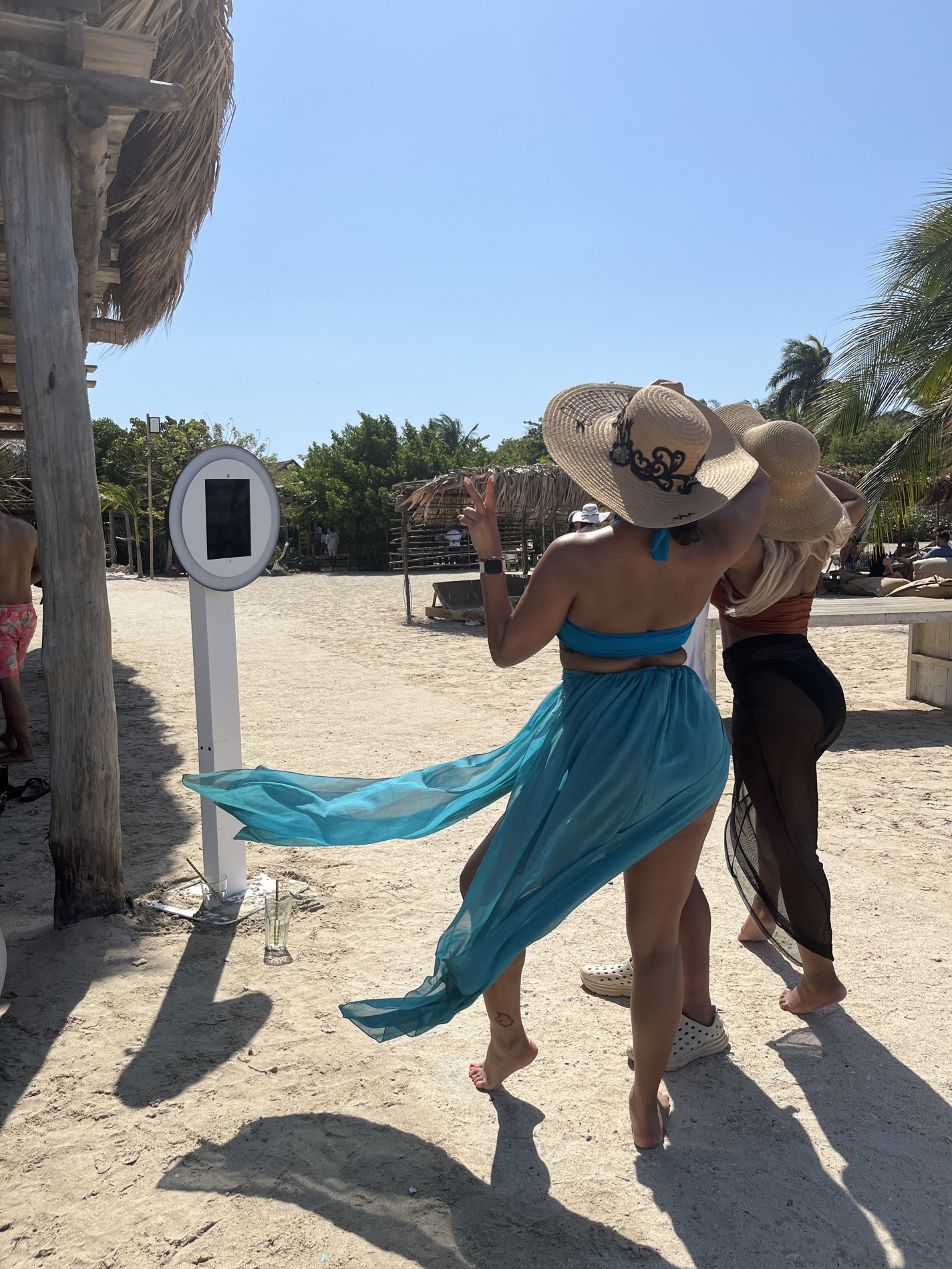 Guests choosing a playful pose in front of the beach selfie booth